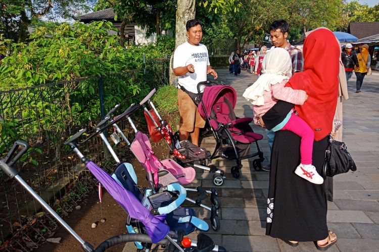 Salah satu keluarga sedang menawar persewaan stroller untuk balita yang tersedia di Candi Borobudur, Magelang, Jawa Tengah ,Sabtu (10/3/2018).