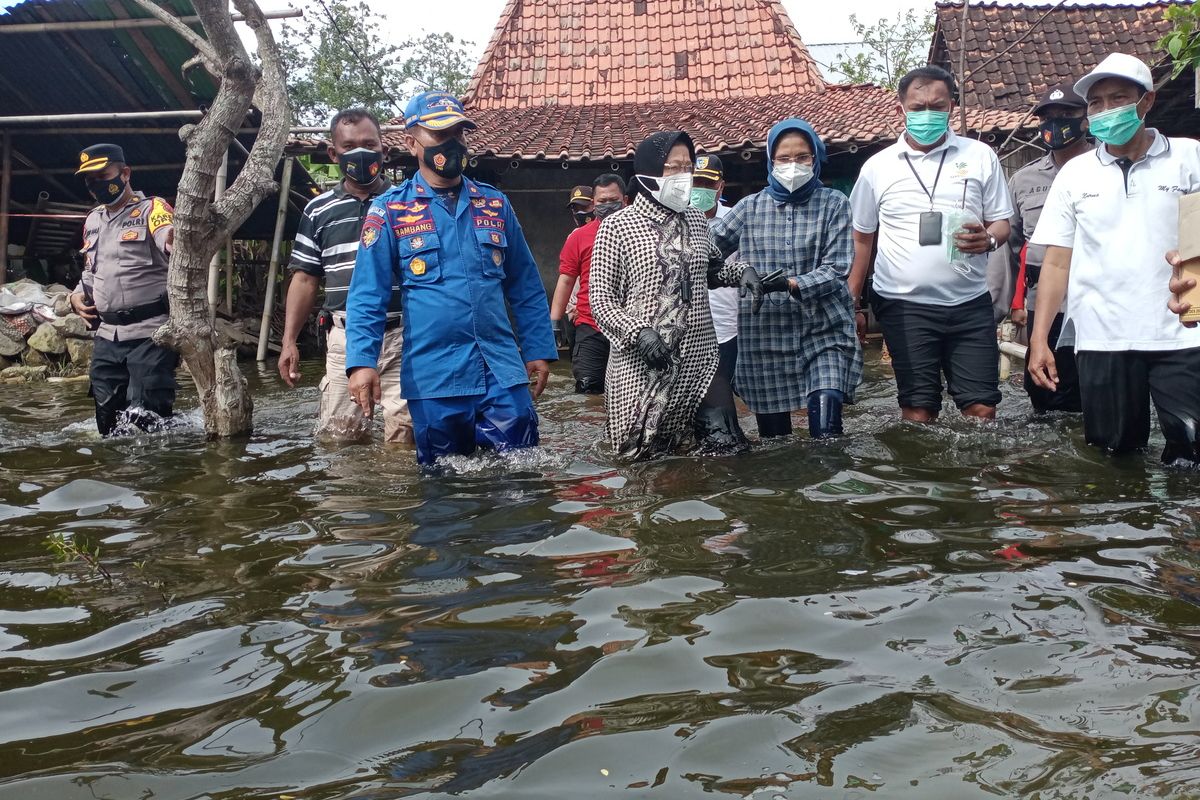 Menteri Sosial Republik Indonesia, Tri Rismaharini, menerobos genangan banjir seusai memberikan bantuan kepada korban banjir di Dukuh Dempel Desa Kalisari Kecamatan Sayung Kabupaten Demak Jawa Tengah yang sudah sepekan ini terendam banjir, Jumat (12/2/2021).