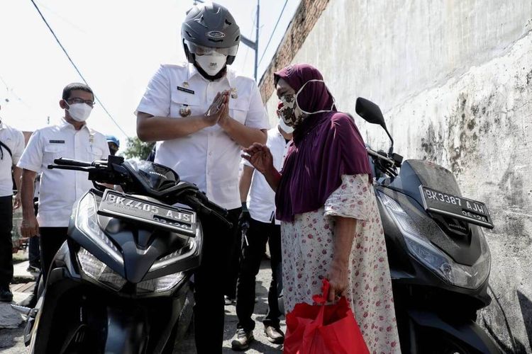 Wali Kota Medan Bobby Nasution menaiki sepeda motor mendatangi beberapa rumah warga dan memberi bantuan sembako, Kamis (29/7/2021)