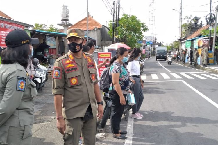 Petugas gabungan melakukan operasi yustisisi penerapan Prokes di salah satu ruas jalan Kota Denpasar, Selasa (12/1/2021)