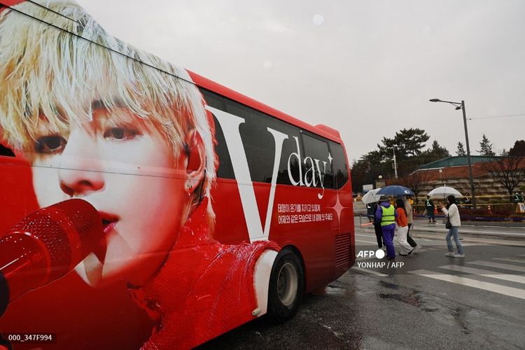 Sebuah bus bergambar wajah V BTS diparkir di depan gerbang pusat pelatihan militer di Nonsan, Korea Selatan, Senin (11/12/2023). Dua member BTS, yakni RM dan V BTS, tiba di pusat pelatihan tersebut untuk menjalani wajib militer. 