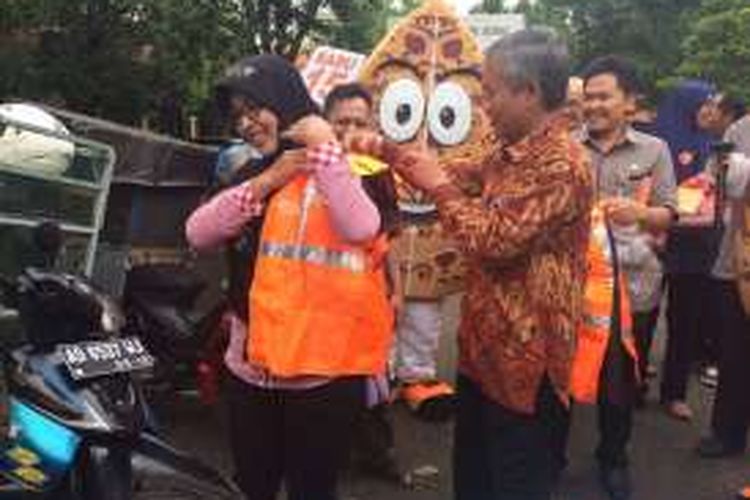 Ketua KPU Jawa Tengah, Joko Purnomo mengenakan rompi ke tukang sayur keliling yang menjadi relawan KPU Batang untuk sosialisasi pilkada serentak 2017 mendatang.