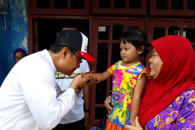 Gus Ipul mencium tangan anak saat blusukan di kampung nelayan Kenjeran, Surabaya.