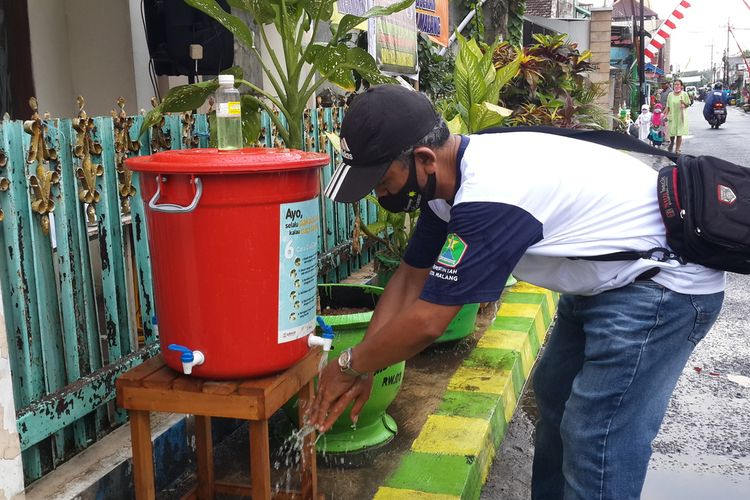 Ketua RW 01 Kelurahan Tunjungsekar, Kota Malang, Ahmad Kasim saat mencuci tangan di depan rumah salah satu warga, Kamis (15/10/2020).