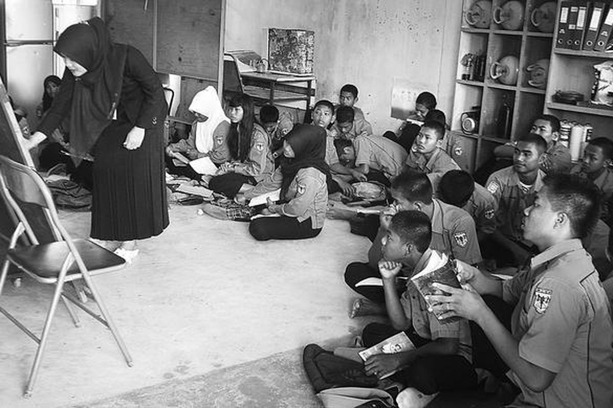 Murid SMKN 3 Batam, Kepulauan Riau, terpaksa duduk di lantai ruangan praktikum saat belajar teori, Rabu (18/1). SMK dengan enam jurusan dan 16 kelas itu hanya punya delapan ruangan sehingga  sebagian murid tidak bisa  belajar di dalam ruangan.