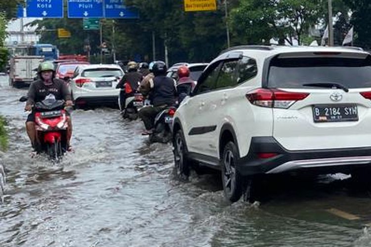 Banjir merendam ruas Jalan Letjen S Parman, Jakarta Barat pada Jumat (24/2/2023). Pengendara sepeda motor dan mobil tetap nekat melintasi kawasan ini. 