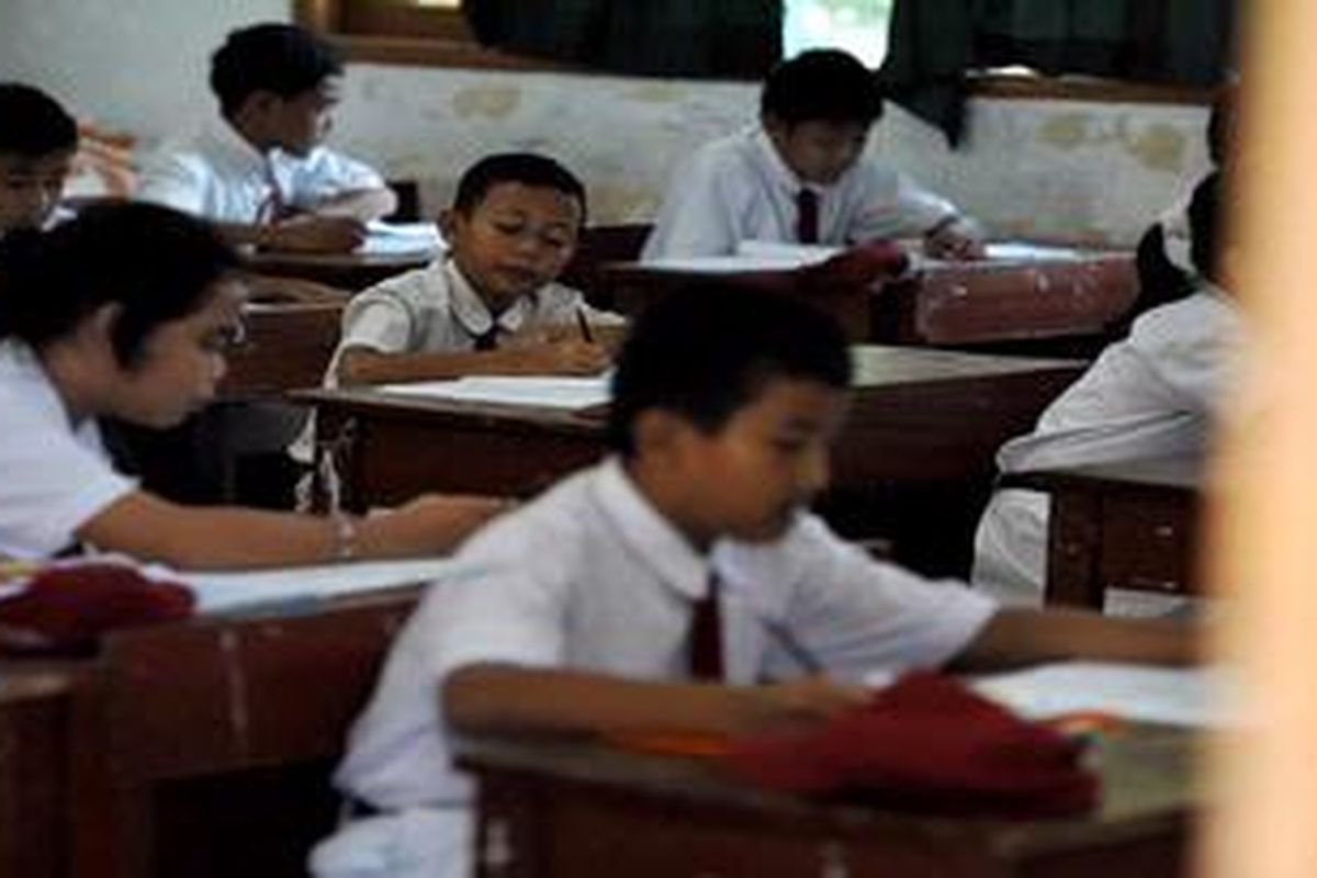 Murid SDN Kemiri Muka 02, Beji, Depok, mengerjakan soal Bahasa Indoensia pada hari pertama ujian nasional di sekolah mereka, Senin (6/5/2013). Pelaksanaan ujian nasional di sekolah ini lancar yang diikuti 19 siswa.