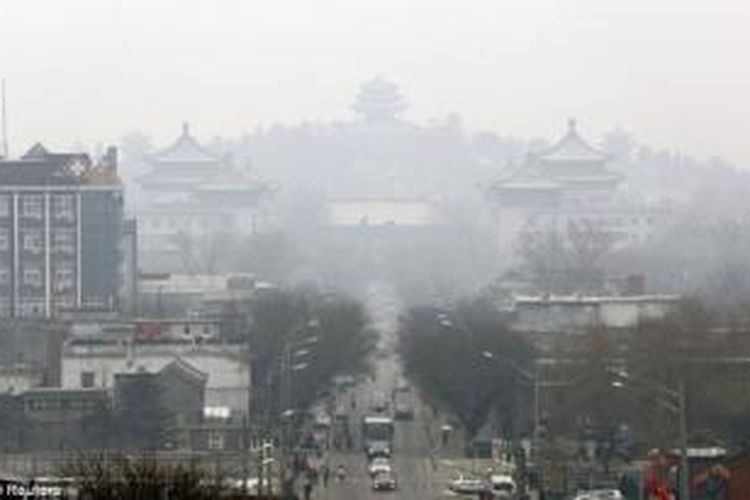 Sejumlah kendaraan terlihat di jalan dekat Taman Jingshan di tengah kabut tebal di pusat kota Beijing