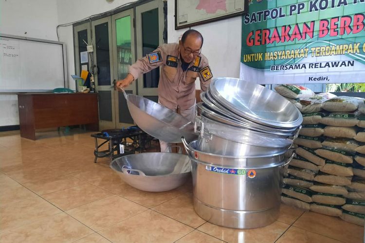 Nur Khamid dengan panci masak untuk dapur umum.