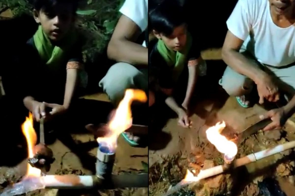 Seorang anak dan orang dewasa di Desa Bangkes, Kecamatan Kadur, Kabupaten Pamekasan, memanggang daging di sebuah sumur bor yang mengeluarkan gas yang disulut kemudian mengeluarkan api.
