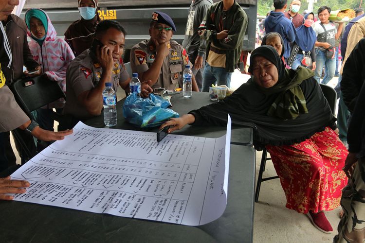 Anggota keluarga penumpang KM Sinar Bangun melihat daftar nama penumpang yang hilang, di posko Pelabuhan Tigaras, Danau Toba, Simalungun, Sumatera Utara, Selasa (19/6/2018). KM Sinar Bangun yang mengangkut ratusan penumpang tenggelam di Danau Toba pada Senin sore, dengan dilaporkan 1 penumpang tewas, belasan selamat, dan ratusan lainnya masih dalam proses pencarian.