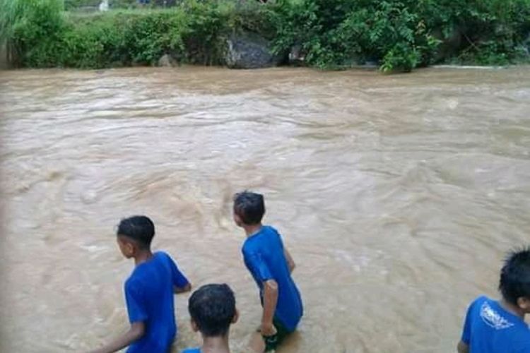 Foto : Siswa-siswi SMP Satap Reca, asal Desa Compang Weluk, Kecamatan Poco Ranaka, Kabupaten Manggarai Timur, NTT melawan derasnya arus kali Wae Rina, Selasa (18/2/2020).