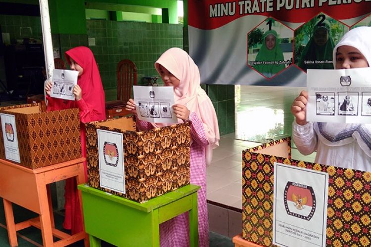 Para siswi MINU Trate Putri Gresik menunjukkan surat suara dalam proses pemilihan.