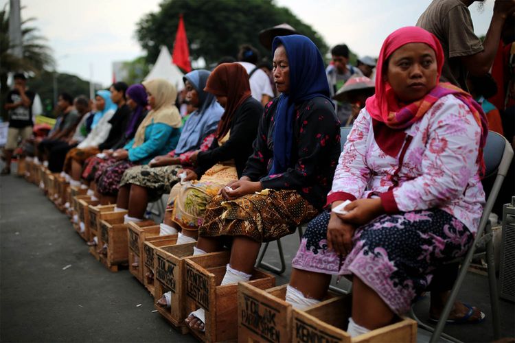 Patmi berkerudung biru (48 tahun) salah seorang petani perempuan asal kawasan Pegunungan Kendeng yang melakukan aksi mengecor kaki di depan Istana Negara, Jakarta, meninggal dunia pada Selasa (21/3/2017) dini hari. Patmi mengalami serangan jantung dan meninggal dalam perjalanan dari kantor LBH Jakarta menuju Rumah Sakit St. Carolus, Salemba, Jakarta Pusat.