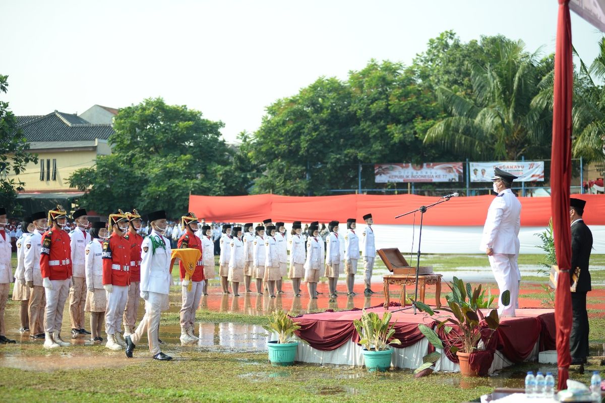 Pasukan pengibar bendera (paskibra) mengibarkan Bendera Merah Putih dalam upacara peringatan hari ulang tahun (HUT) ke-77 RI di Lapangan Stadion Mini Larangan Indah, Kecamatan Larangan, Kota Tangerang, pada Rabu (17/8/2022). Lapangan tersebut becek karena sehari sebelumnya diguyur hujan.