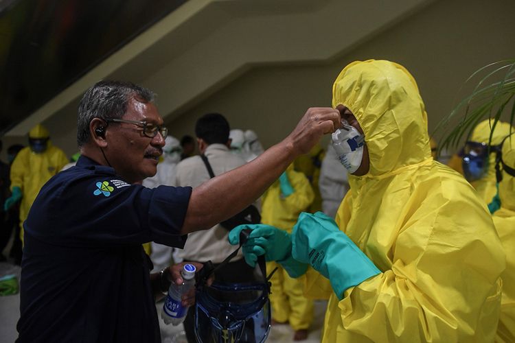 Sejumlah petugas mengenakan pakaian pelindung lengkap saat bersiap menyambut kedatangan kru kapal pesiar Diamond Princess yang dinyatakan negatif virus corona di Bandara Kertajati, Kabupaten Majalengka, Jawa Barat, Minggu (1/3/2020). Pemerintah mengevakuasi 69 kru kapal pesiar Diamond Princess dari Yokohama, Jepang dan selanjutnya akan menjalani proses observasi di Pulau Sebaru Kecil, Kepulauan Seribu, Jakarta.