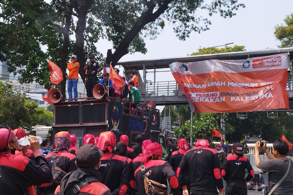 Relawan Partai Buruh dan KSPSI menggelar aksi di kawasan Patung Kuda, Jalan Medan Merdeka Barat, Gambir, Jakarta Pusat, Jumat (27/10/2023). (KOMPAS.com/XENA OLIVIA)