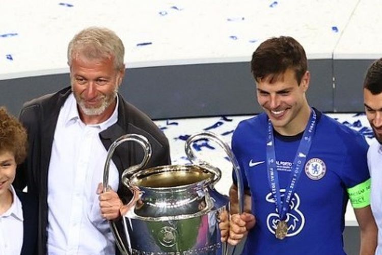 Pemilik Chelsea Roman Abramovich tersenyum saat mengangkat trofi Liga Champions bersama kapten Cesar Azpilicueta.