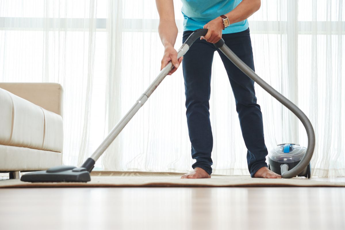 Ilustrasi menggunakan vacuum cleaner untuk membersihkan karpet.