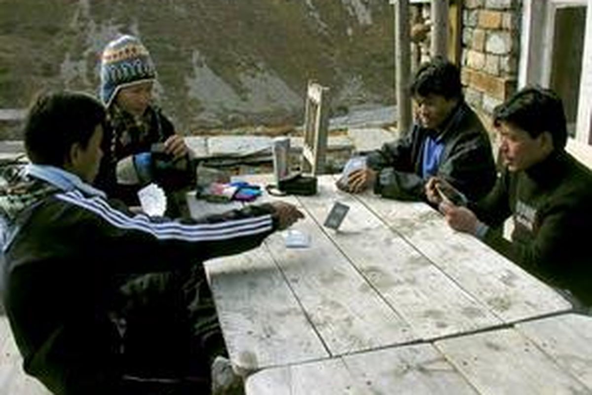 Para porter bermain kartu mengisi senja yang dingin. 