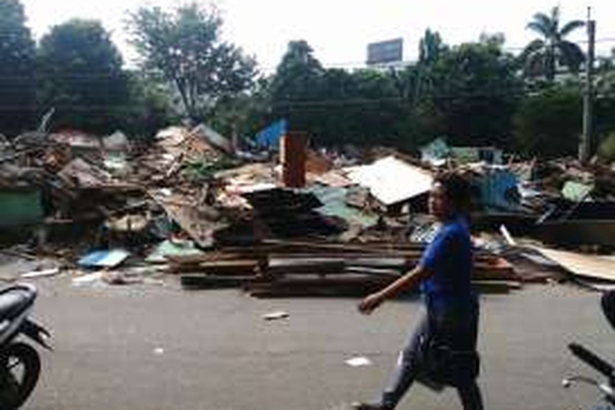 Seorang pejalan kaki melintas di depan bangunan panti asuhan Yayasan Shohibul Al-Istiqomah di Rawajati yang sudah rata tanah digusur kemarin. Kini anak asuh di panti tersebut sudah pindah ke tempat baru di kawasan Cililitan, Jakarta Timur. Jumat (2/9/2016) 