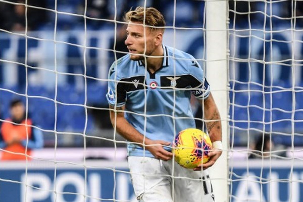 Ciro Immobile memungut bola dari gawang setelah mencetak gol kelima Lazio dalam laga kontra Sampdoria di Stadion Olimpico, Roma, Sabtu (18/1/2020). 
