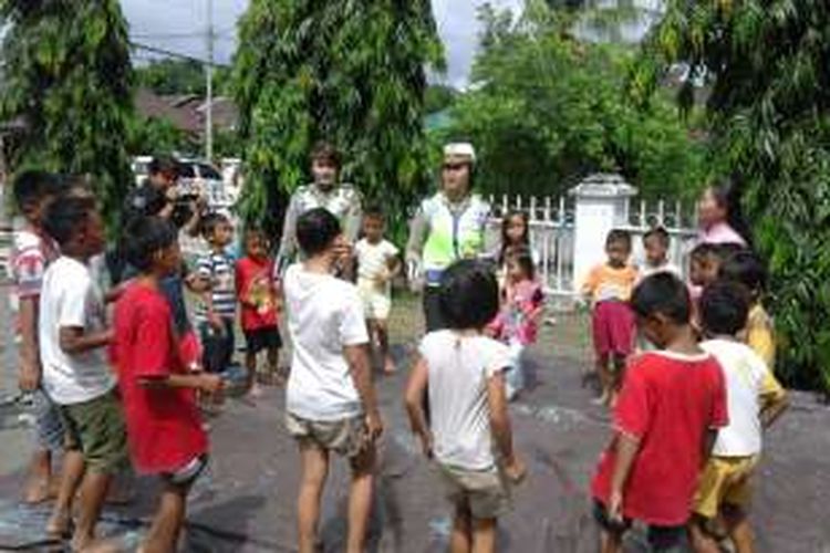 Polisi wanita mencoba mengajak anak-anak korban bencana Sangihe bermain.