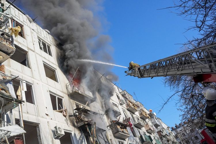 Petugas pemadam kebakaran Ukraina mencoba memadamkan api setelah serangan udara menghantam kompleks apartemen, di Kharkiv, Ukraina, Kamis (24/2/2022). 