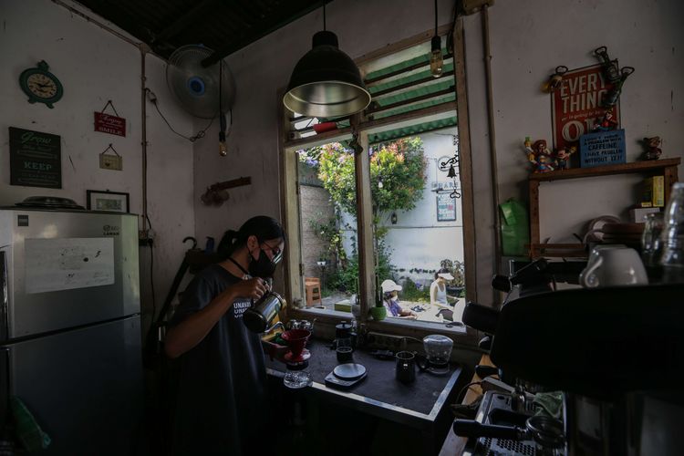 Pelanggan berjemur sembari ngopi di warung kopi Nyambi Ngopi, Depok, Jawa Barat, Jumat (30/7/2021). Cara unik bersiasat di tengah pandemi Covid-19 ini dibatasi 5 orang tiap sesi untuk menjaga protokol kesehatan.