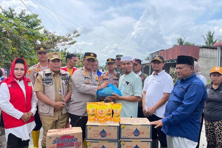 Kapolres Rohul AKBP Budi Setiyono saat menyerahkan bantuan sembako kepada warga yang terdampak banjir, di Desa Sontang, Kecamatan Bonai Darussalam, Kabupaten Rokan Hulu, Riau, Rabu (3/1/2024).