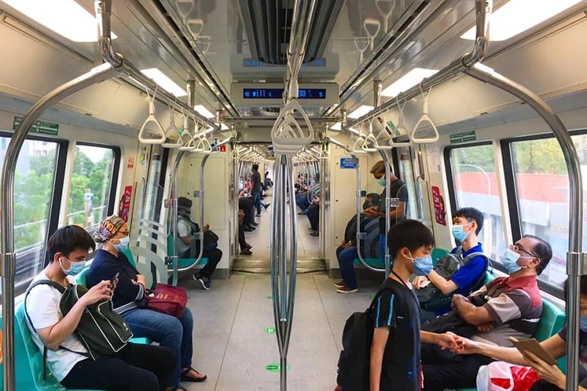 Di tengah pandemi virus corona, warga Singapura memakai masker dan duduk berjarak minimal 1 kursi kosong ketika menggunakan Mass Rapid Transit (MRT) Singapura jalur Timur-Barat atau warna hijau di kawasan Queenstown, Minggu sore (19/04/2020)