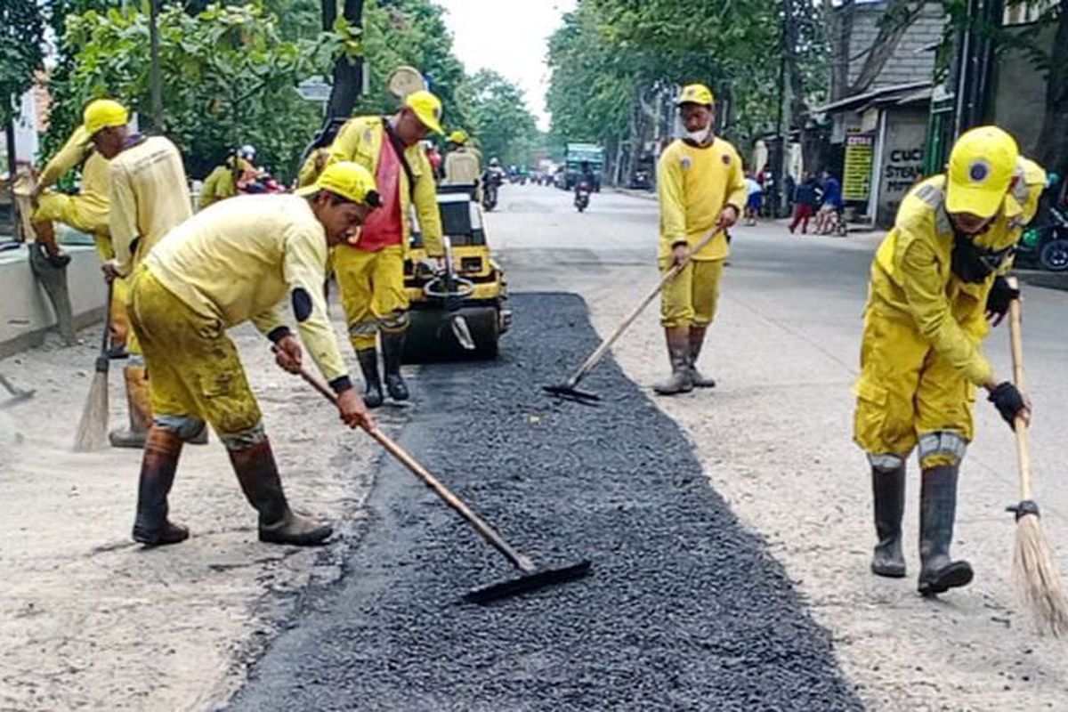 Petugas Suku Dinas Bina Marga Jakarta Utara tengah melakukan perbaikan jalan rusak di Kelurahan Semper TImur, Kecamatan Cilincing, Jakarta Utara, Selasa (15/2/2022).