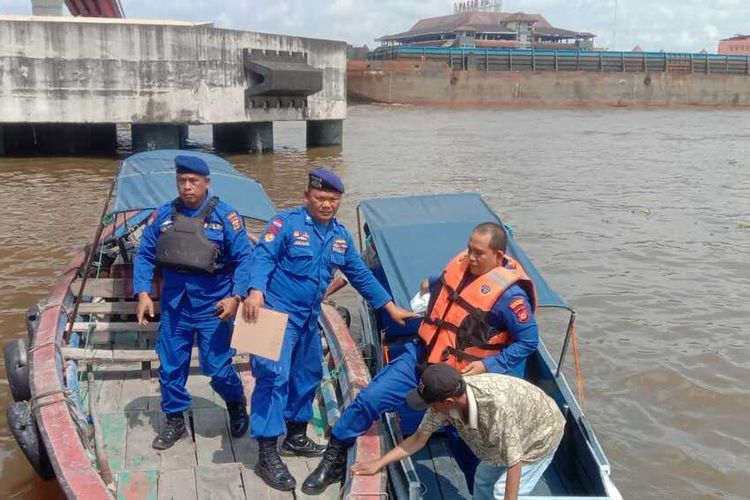 Polisi bersama warga saat melakukan evakuasi terhadap HA (25) yang melompat dari atas Jembatan Ampera Palembang, Selasa (29/11/2022).