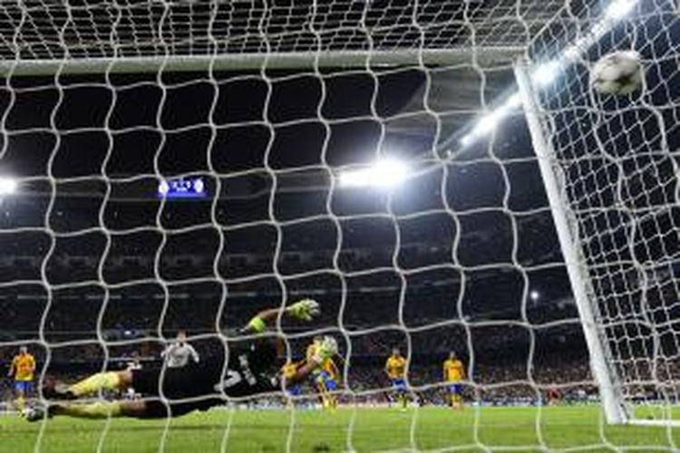 Bola hasil tembakan gelandang Real Madrid Cristiano Ronaldo dari titik penalti mendesak jaring gawang Juventus, pada babak pertama pertandingan Liga Champions, di Santiago Bernabeu, Rabu (23/10/2013).