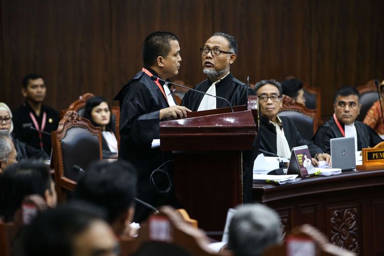 Ketua Tim Hukum pasangan Prabowo Subianto-Sandiaga Uno, Bambang Widjojanto (berdiri-kanan) terlihat berdiskusi dengan anggota tim hukum Denny Indrayana di sidang perdana sengketa pilpres 2019 di Gedung Mahkamah Konstitusi, Jakarta, Jumat (14/6/2019).