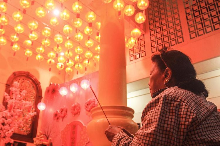 Seorang warga keturunan Tionghoa sedang melaksanakan sembahyang di di malam Imlek yang ada di Wihara Dharmakirti, Jalan Papera, Kecamatan Ilir Timur I, Palembang, Sumatera Selatan, Kamis (11/2/2021). Tradisi tahunan menyalakan ratusan lilin pelita kembali dilakukan di malam Imlek tersebut sebagai simbol penerangaan dalam agama Buddha.