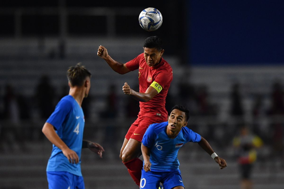 Kapten Timnas Indonesia Timnas Indonesia (atas) menyundul bola dibayangi pemain Timnas Singapura dalam pertandingan Grup B SEA Games 2019 di Stadion Rizal Memorial, Manila, Filipina, Kamis (28/11/2019). ANTARA FOTO/Sigid Kurniawan/foc.