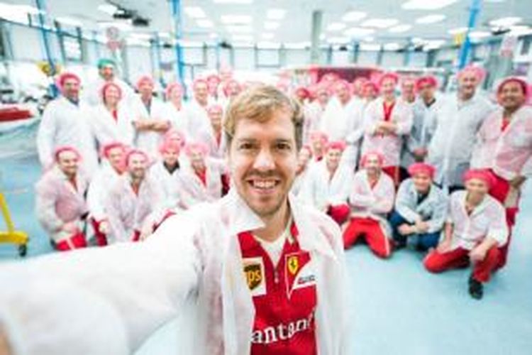 Pebalap Ferrari, Sebastian Vettel, berpose bersama kru saat mengunjungi markas Ferrari di Maranello, Italia, Kamis (15/1/2014).