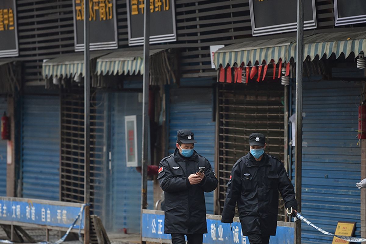 Petugas keamanan berpatroli di pasar ikan tradisional Huanan di kota Wuhan, China, Jumat (24/1/2020). Pasar ikan itu ditutup setelah virus corona yang mematikan dideteksi berasal dari pasar itu.