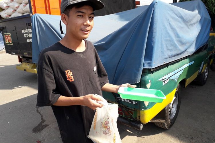 Kamil (17 tahun) menunjukkan beras ceceran yang didapatkannya dari Pasar Induk Cipinang, Jakarta Timur, Sabtu (11/5/2018).