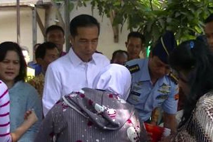 Jokowi dan Iriana membagi sembako gratis di Solo, Sabtu (18/7/2015). 