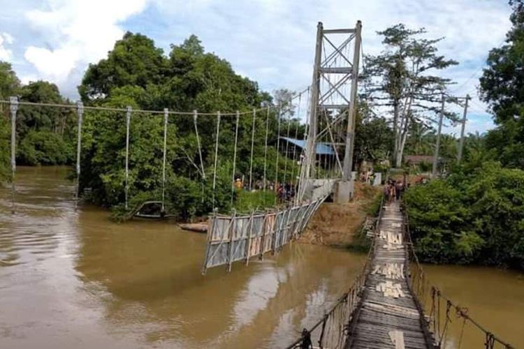 Jembatan gantung yang tengah dalam proses pembangunan di Sungai Keli, Kecamatan Ngabang, Kabupaten Landak, Kalimantan Barat, ambruk, Selasa (16/6/2020).  Peristiwa tersebut juga mengakibatkan dua orang pekerja, bernama Yono (34) dan Soijan (27), ikut terjatuh ke sungai dan sampai dengan saat ini masih dalam proses pencarian.