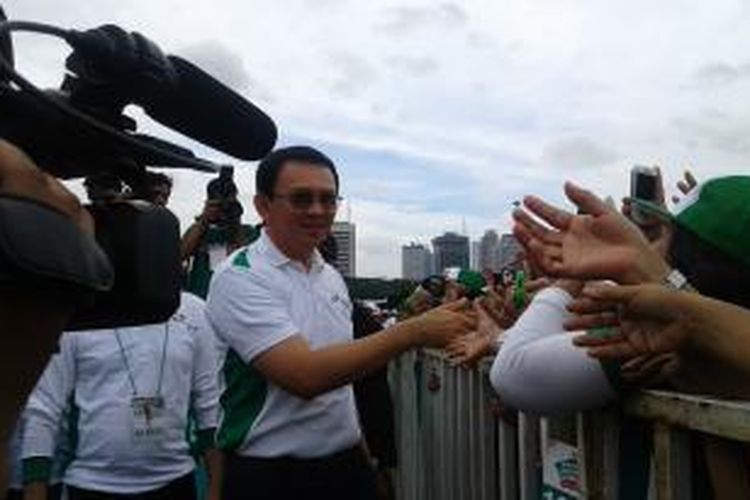 Gubernur DKI Jakarta Basuki Tjahaja Purnama menyalami ibu-ibu peserta acara Hari Osteoporosis di Monas, Minggu (7/12/2014).