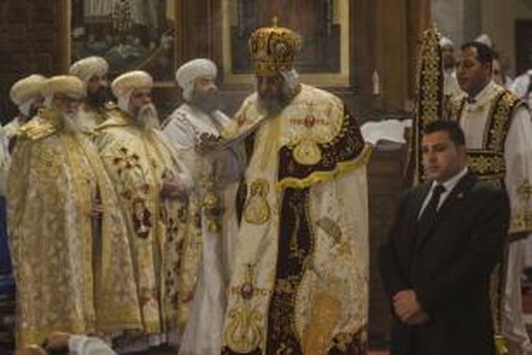 Pemimpin gereja Koptik, Paus Tawadros II memimpin misa malam Natal, Senin (6/1/2014), di Kairo sementara petugas keamanan berpakaian sipil menjaga ketat tak jauh dari altar.