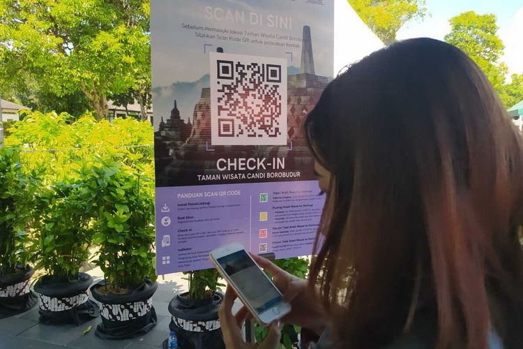 Seorang wisatawan scan QR barcode pada aplikasi PeduliLindungi sebelum masuk ke Taman Wisata Candi Borobudur, Magelang, Jawa Tengah, Minggu (19/9/2021)