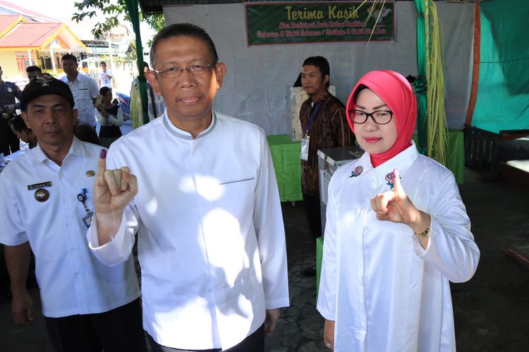 Calon Gubernur Kalbar, Sutarmidji (kedua kiri) bersama istri memperlihatkan jari kelingking bertinta biru usai pencoblosan Pilgub Kalbar di TPS 006, Kelurahan Sungai Beliung, Pontianak, Rabu (27/6/2018). Pilgub Kalbar 2018 diikuti tiga pasangan calon dan digelar di 14 kabupaten/kota se-Kalbar, memperebutkan 3.436.127 suara. 





Walikota Tangerang Arier R Wismansyah (kiri) beserta istri menunjukkan surat suara sesaat sebelum melakukan pencoblosan pada Pilkada Walikota dan Wakil Walikota Tangerang di TPS 7 Karawaci, Tangerang, Banten, Rabu (27/6). Pilkada Walikota dan Wakil Walikota Tangerang hanya diikuti calon tunggal yakni pasangan Arief R Wismansyah dan Sachrudin, selain di Kota Tangerang calon tunggal juga terjadi di Kabupaten Tangerang dan Lebak yang kesemua ada di Provinsi Banten. ANTARA FOTO/Muhammad Iqbal/ama/18