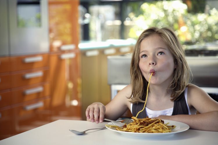 Ilustrasi seorang anak kecil makan pasta dengan cara slurping. 