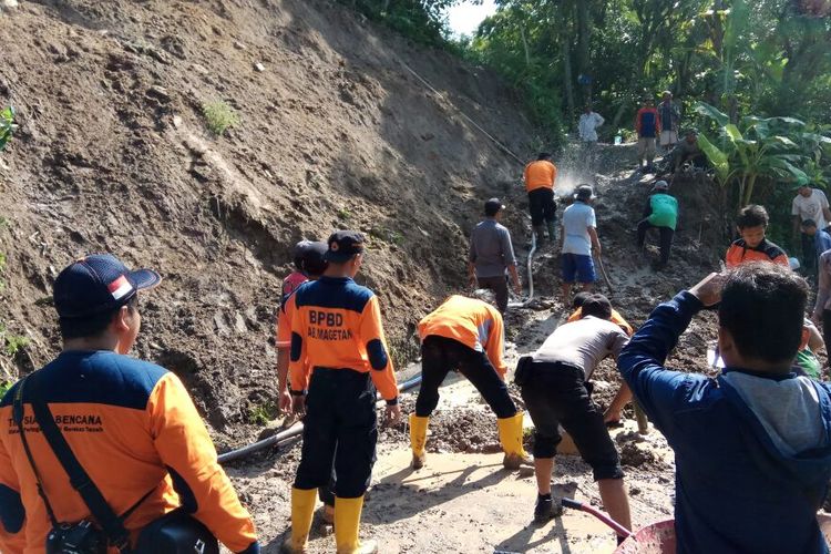 Tim BPBD Magetan bersama warga dan aparat bergotong royong membersihkan material tanah longsor di Dukuh Jurang Banteng, Desa Cileng,Kecamatan Poncol, Magetan, Kamis (2/3/2017).