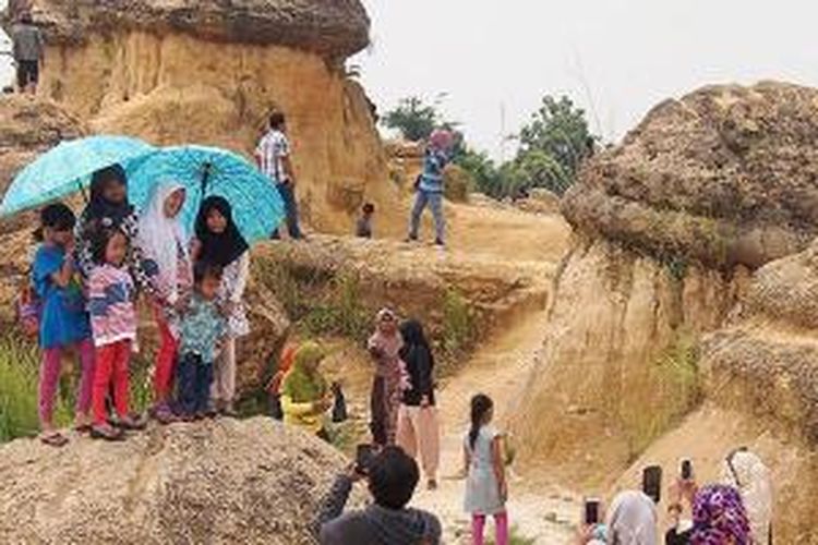 Lokasi eks penambangan bahan galian C di Desa Bungah, Kabupaten Gresik, Jawa Timur, Minggu (19/4/2015), ramai pengunjung. Mereka ingin menikmati bukit jamur. Bagian lahan yang tidak dapat ditambang akibat terkena hujan dan panas ini, akhirnya membentuk bangunan seperti jamur yang baru kuncup. Lokasi itu kini menjadi tempat tujuan wisata baru yang dibuka hanya pada hari Minggu.
