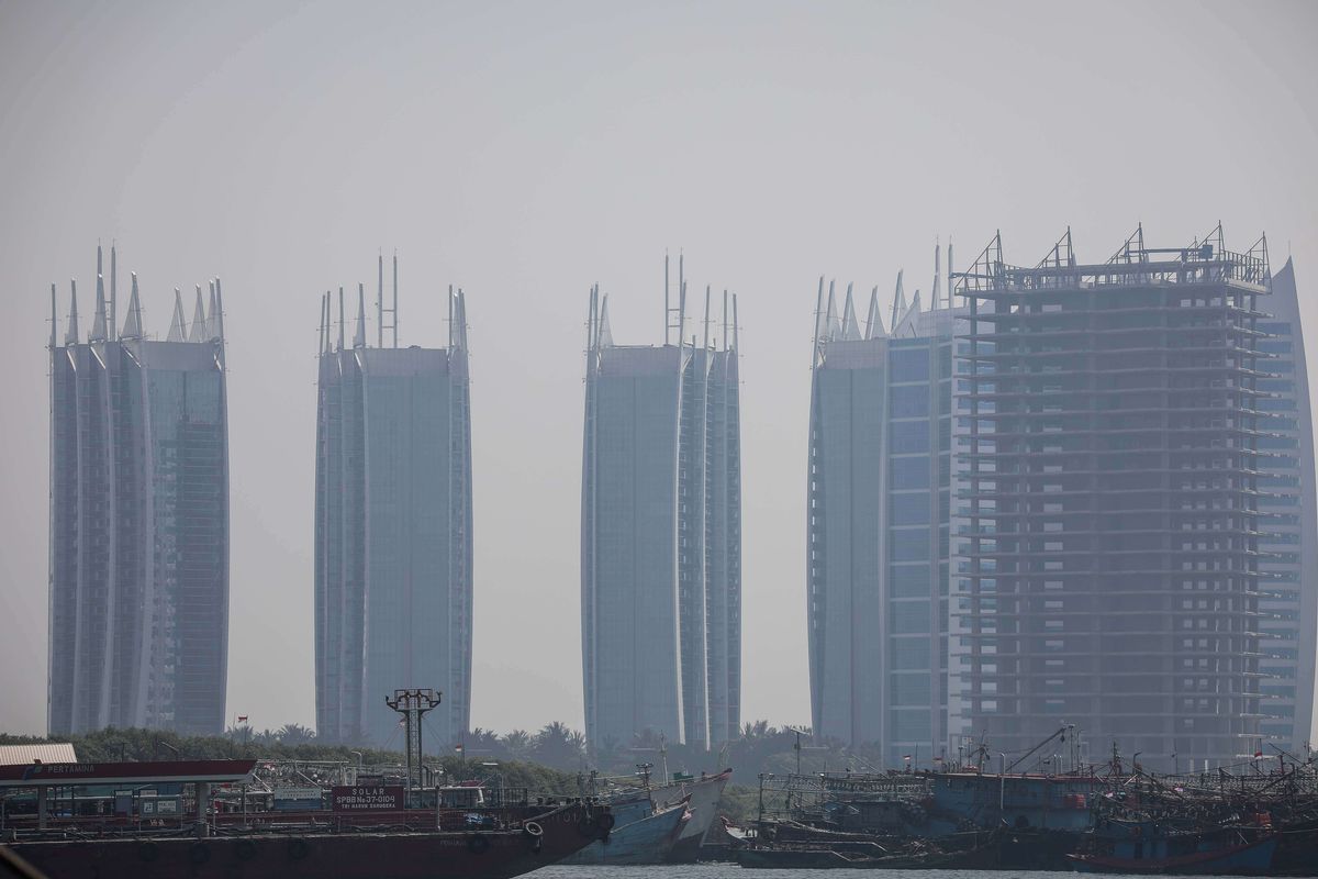 Pemandangan laut dengan latar belakang gedung bertingkat yang diselimuti asap polusi di Jakarta Utara, Rabu (31/7/2019). Berdasarkan data situs penyedia peta polusi daring harian kota-kota besar di dunia AirVisual, menempatkan Jakarta pada urutan pertama kota terpolusi sedunia pada Senin (29/7) pagi dengan kualitas udara mencapai 183 atau dalam kategori tidak sehat.